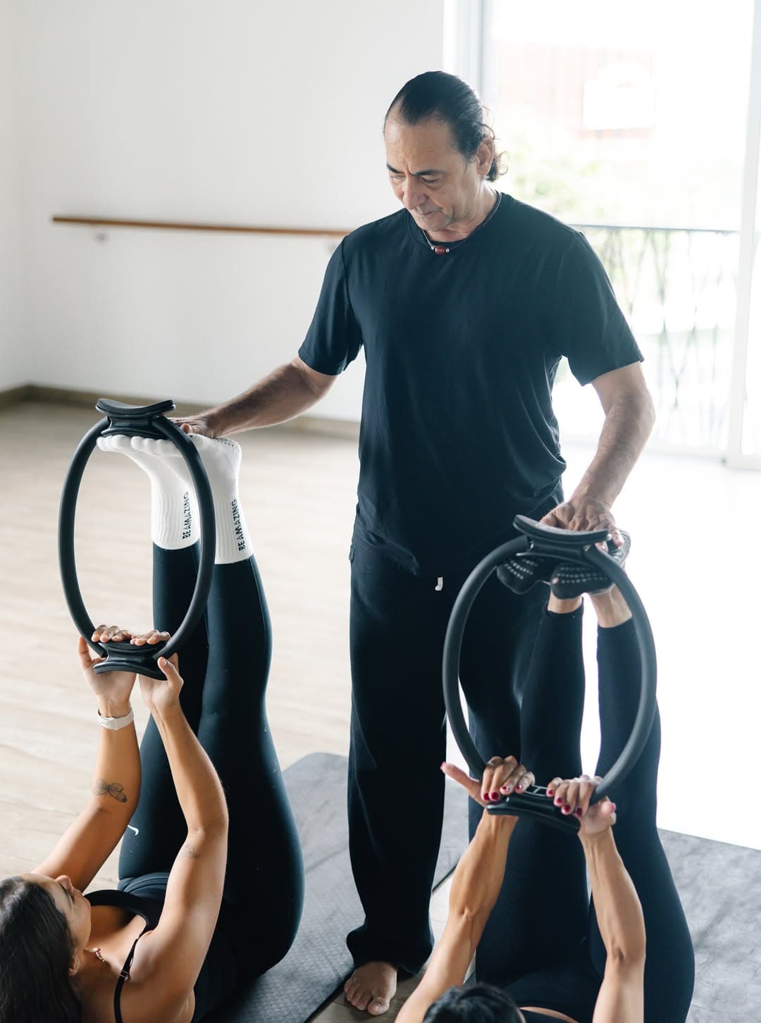 Rafael Alvarez asistiendo a una alumna con el aro de pilates